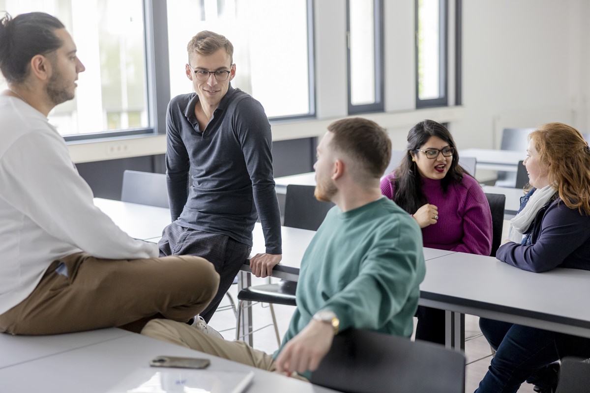 Studenten der Uni Siegen sitzen vor einer Vorlesung gemeinsam im Hörsaal | Foto: Hanna Witte