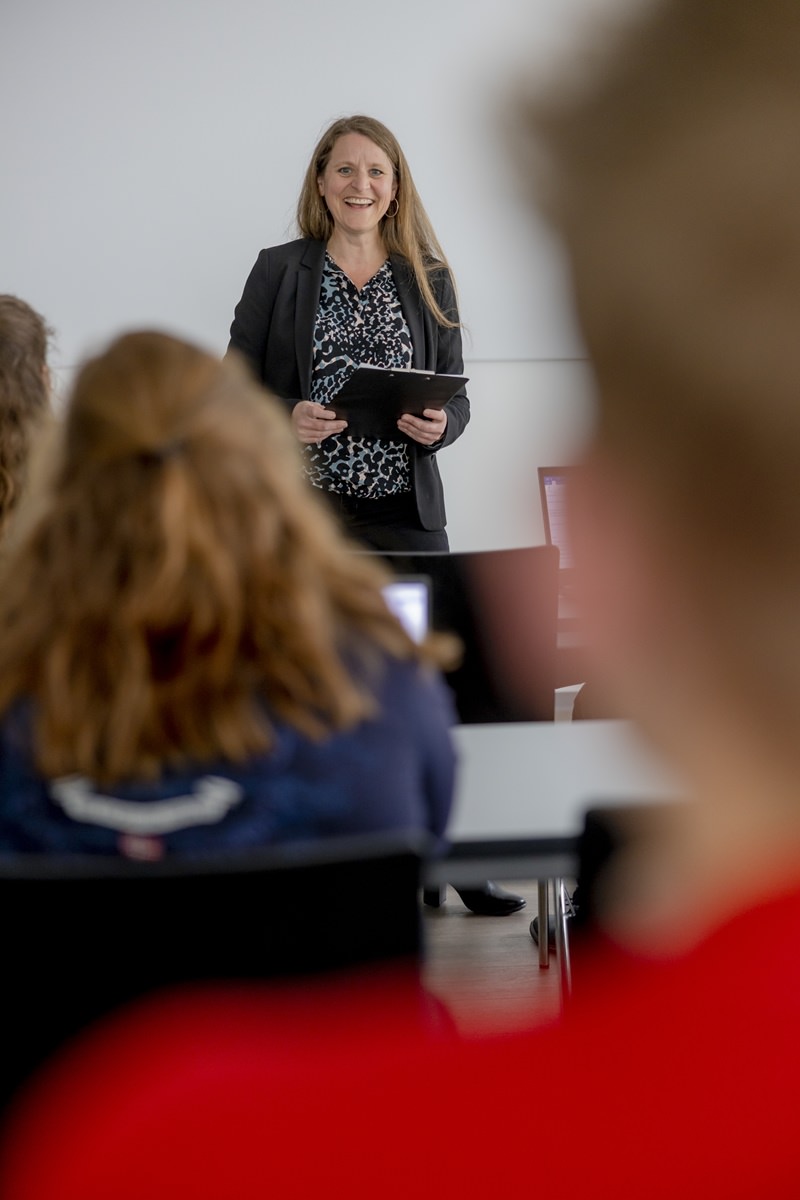 eine Dozentin der Uni Siegen steht während ihrer Vorlesung im Hörsaal vor Studenten | Foto: Hanna Witte