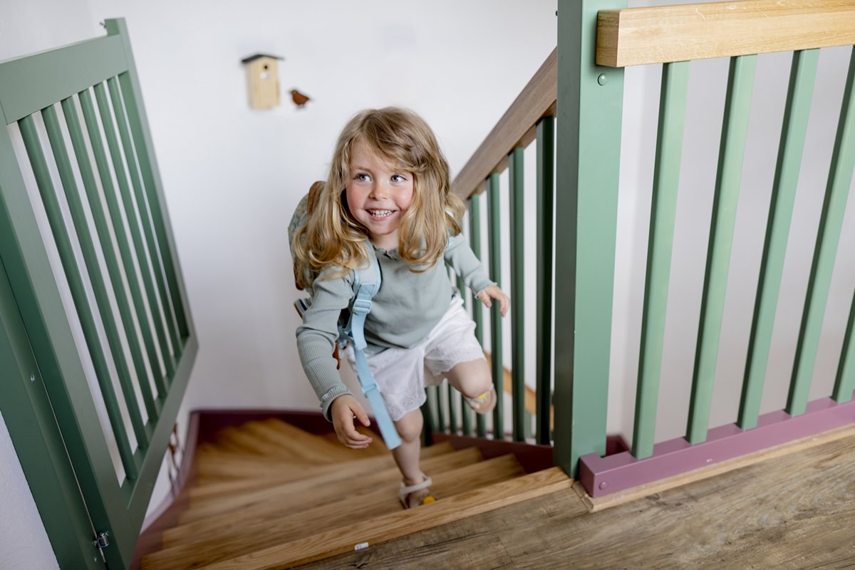 ein Kind läuft aufgeregt die Treppe eines Ferienhauses von Hof Hardthöhe hinauf | Foto: Hanna Witte
