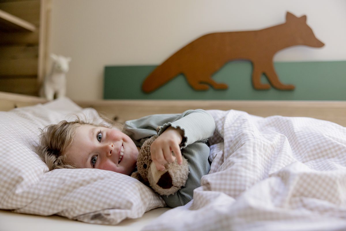 ein Kind liegt im Bett eines Abenteuer-Kinderzimmers in einem Ferienhaus von Hof Hardthöhe | Foto: Hanna Witte