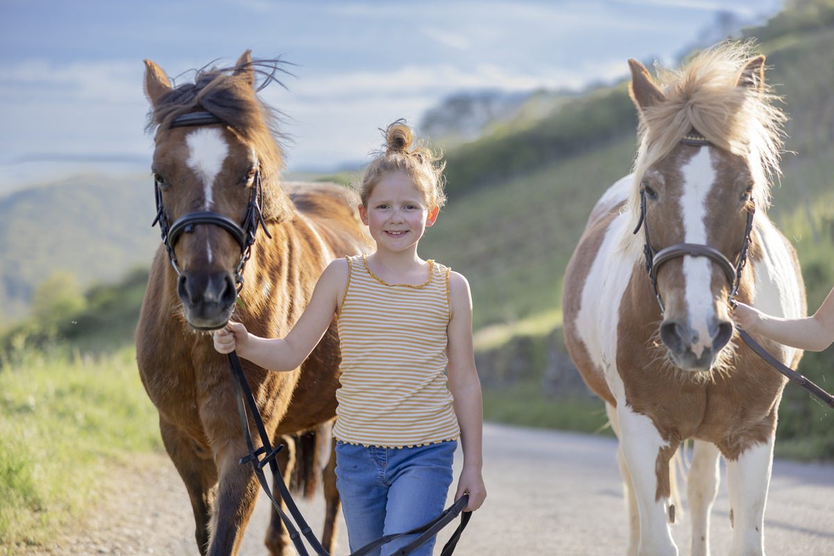 ein Mädchen führt ein Pferd am Zügel über das Gelände von Ferienhof Hardthöhe | Foto: Hanna Witte