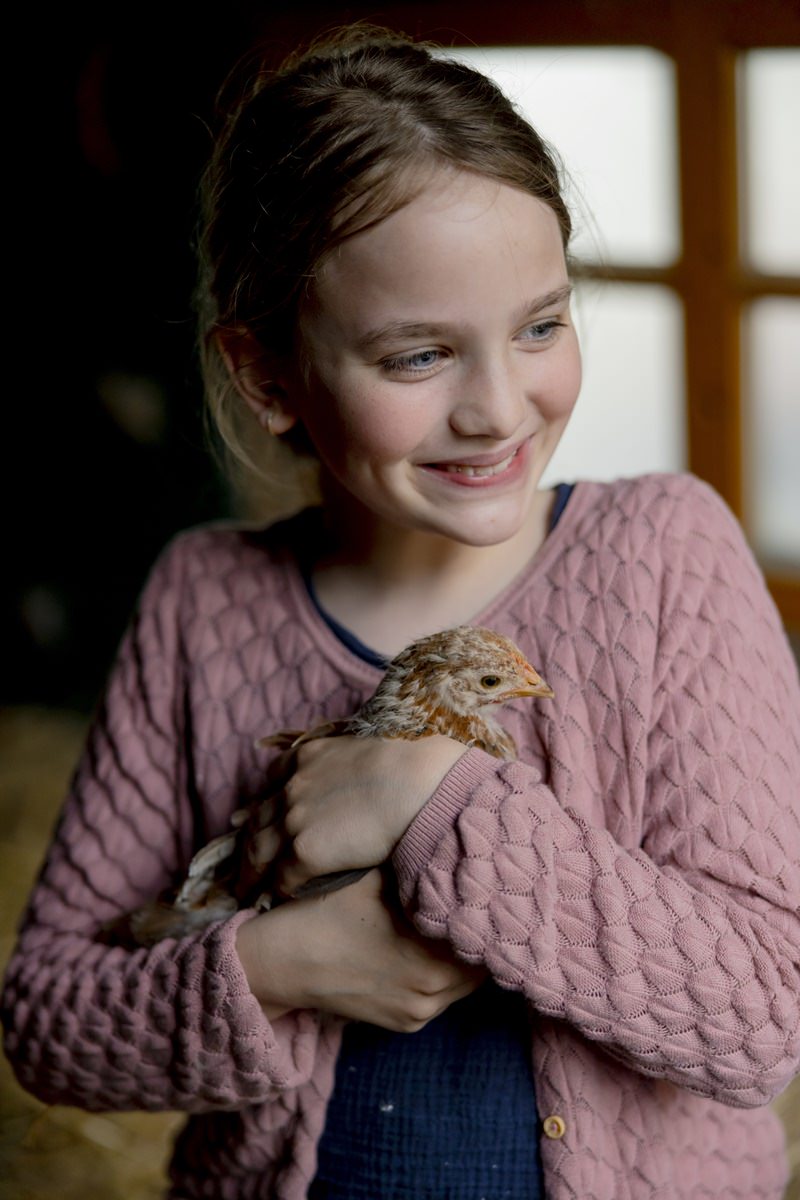 ein Mädchen hält ein Huhn von Ferienhof Hardthöhe im Arm | Foto: Hanna Witte