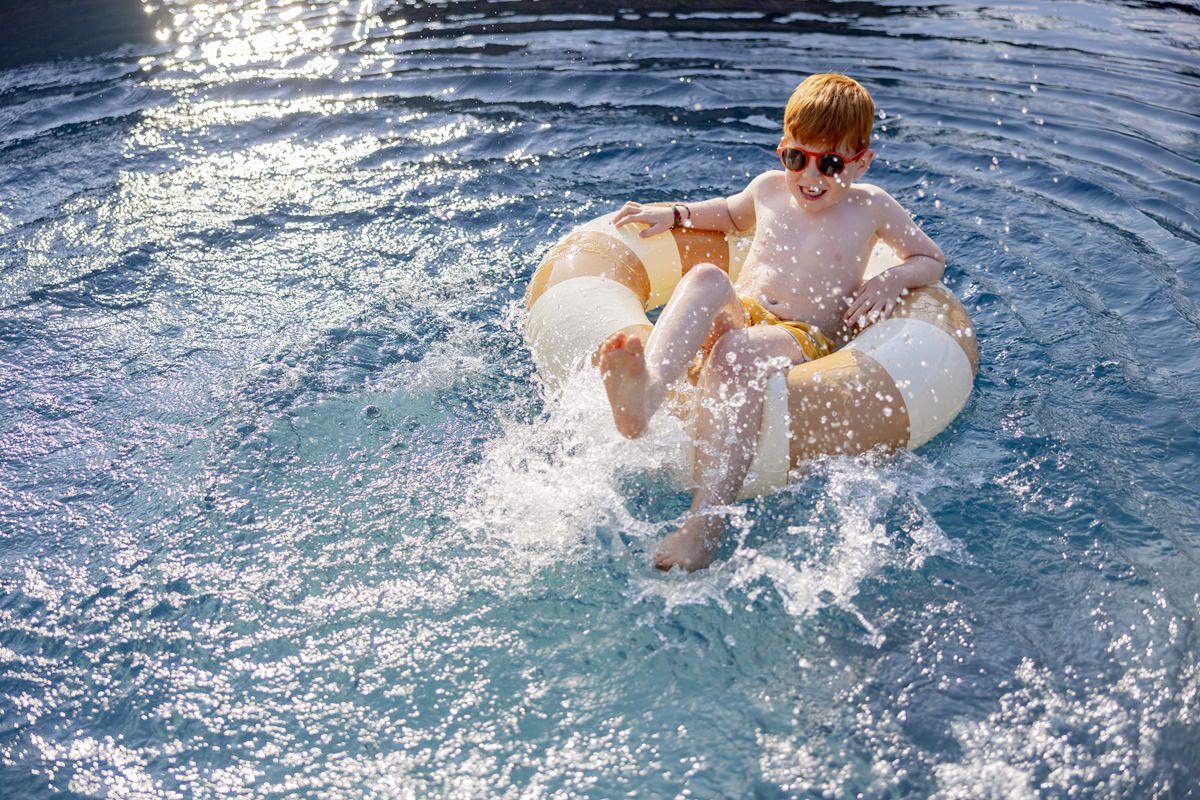 ein Junge sitzt in einem Schwimmreifen im Pool von Ferienhof Hardthöhe und planscht mit den Füßen | Foto: Hanna Witte