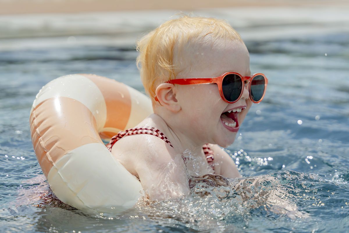 ein kleines Mädchen mit Sonnenbrille planscht mit einem Schwimmreifen im Pool eines Familienhotels | Foto: Hanna Witte