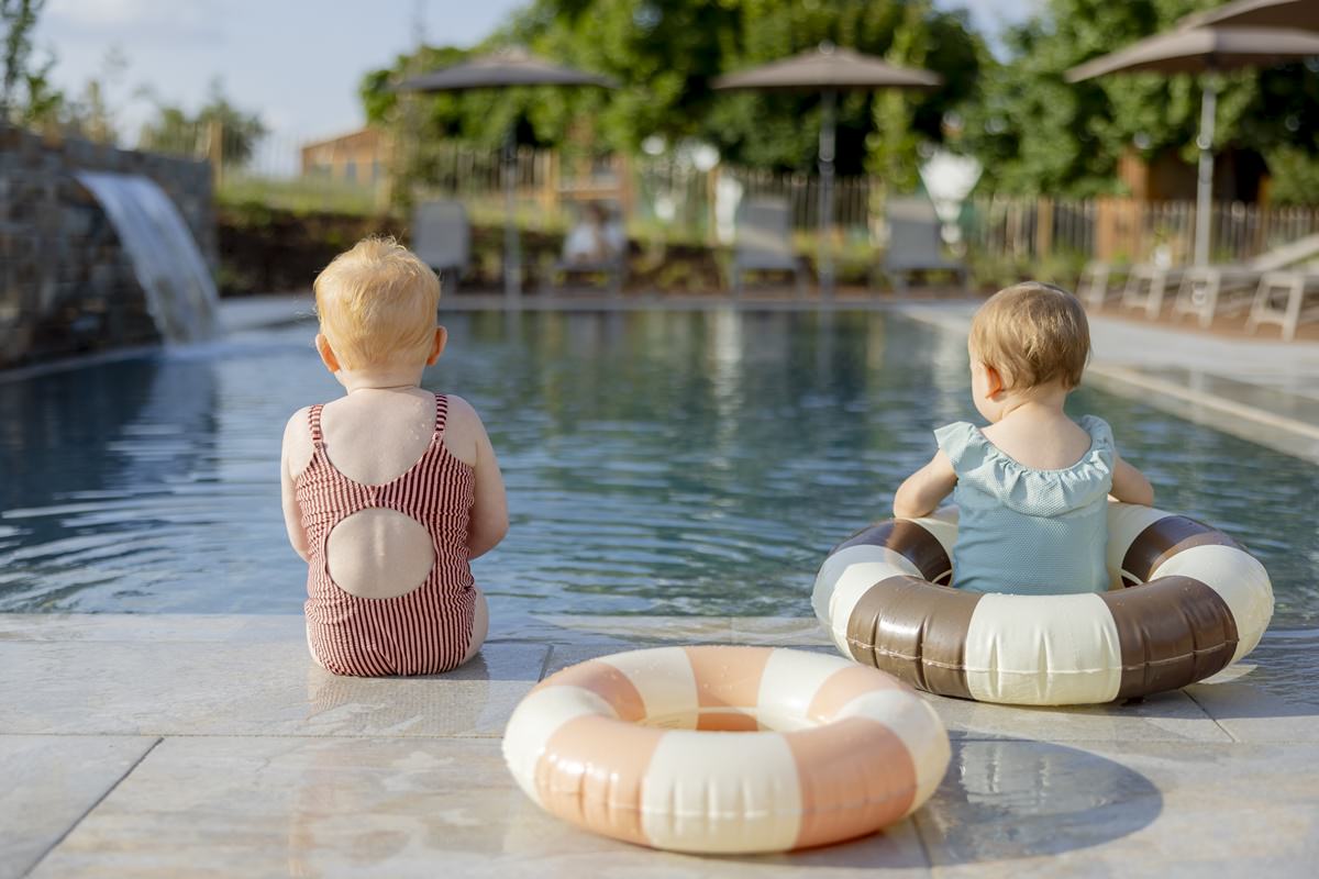 zwei kleine Mädchen sitzen am Rand des Pools von Familienhotel Hardthöhe | Foto: Hanna Witte