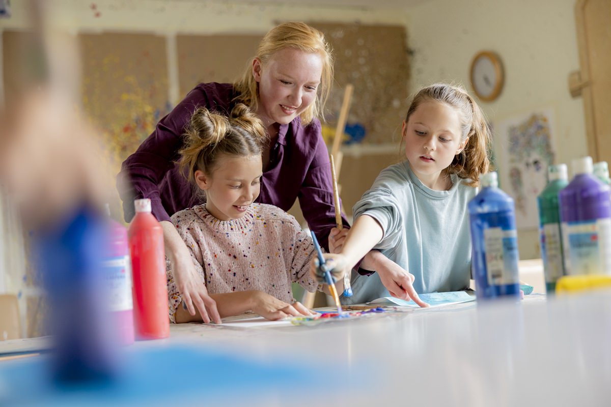 eine Pädagogin der Syltklinik malt mit zwei Mädchen | Foto: Hanna Witte