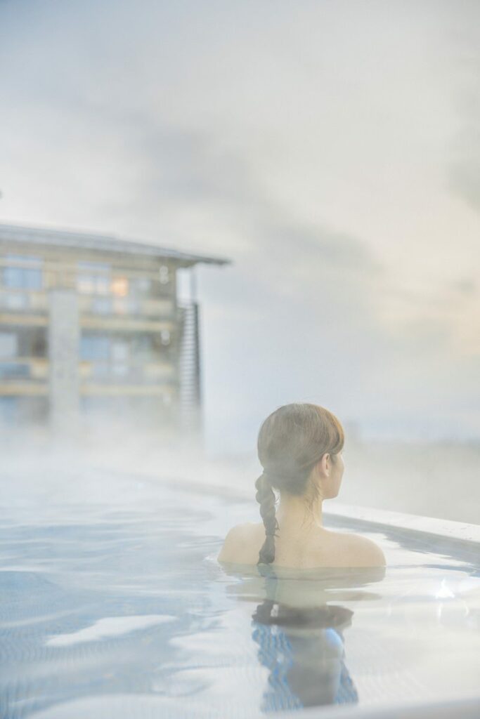 eine Frau schwimmt umgeben von Nebel im Outdoor Pool von Alpenresort Schwarz | Foto: Hanna Witte