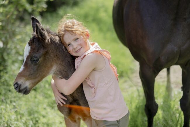 kinderhotel-fotos-freizeitangebote-01 ein Mädchen umarmt ein Pony von Ferienhof Hardthöhe | Foto: Hanna Witte