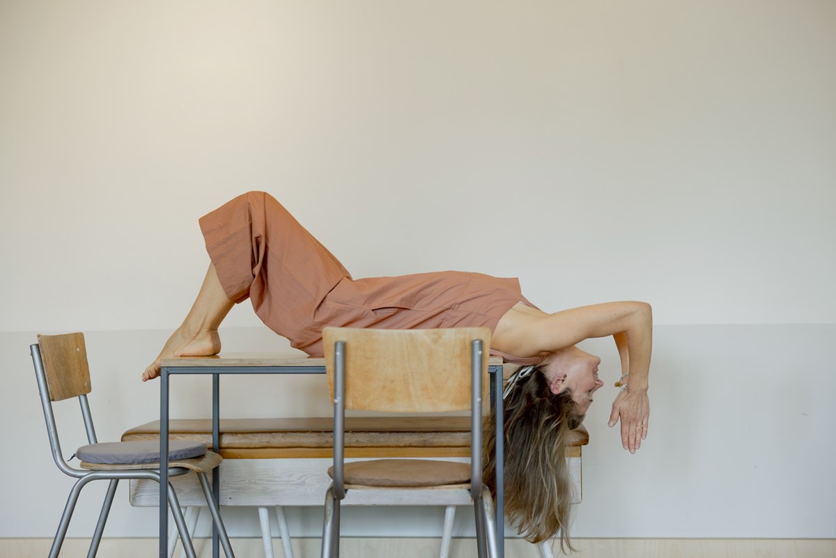 eine Yoga Lehrerin macht auf dem Rücken liegend ein Yoga Asana auf einem Tisch | Foto: Hanna Witte