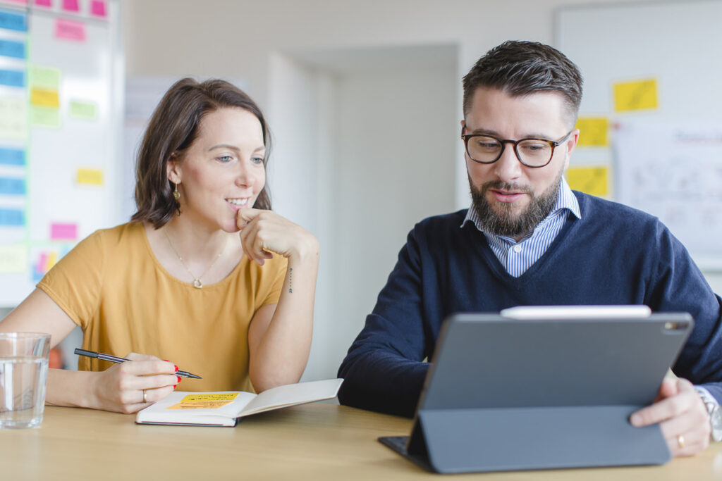 zwei MAERA Mitarbeiter entwickeln Arbeitsschritte mit einem Laptop und einem Notizbuch | Foto: Hanna Witte