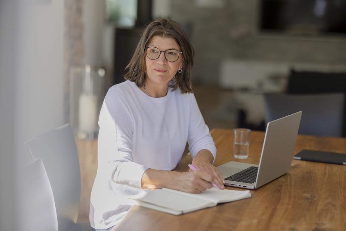 Landwirte Coach Helma Jansen arbeitet mit einem Laptop und einem Notizheft in ihrem Büro | Foto: Hanna Witte