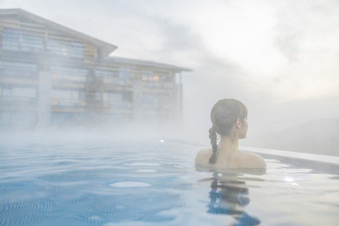 eine Frau steht im outdoor Hotel Pool umgeben von Nebelschwaden | Foto: Hanna Witte